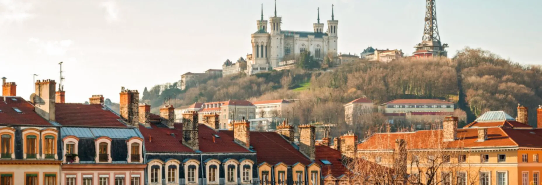 Vue panoramique sur les toits colorés de Lyon, dominés par la colline de Fourvière avec sa célèbre basilique blanche Notre-Dame de Fourvière et la tour métallique