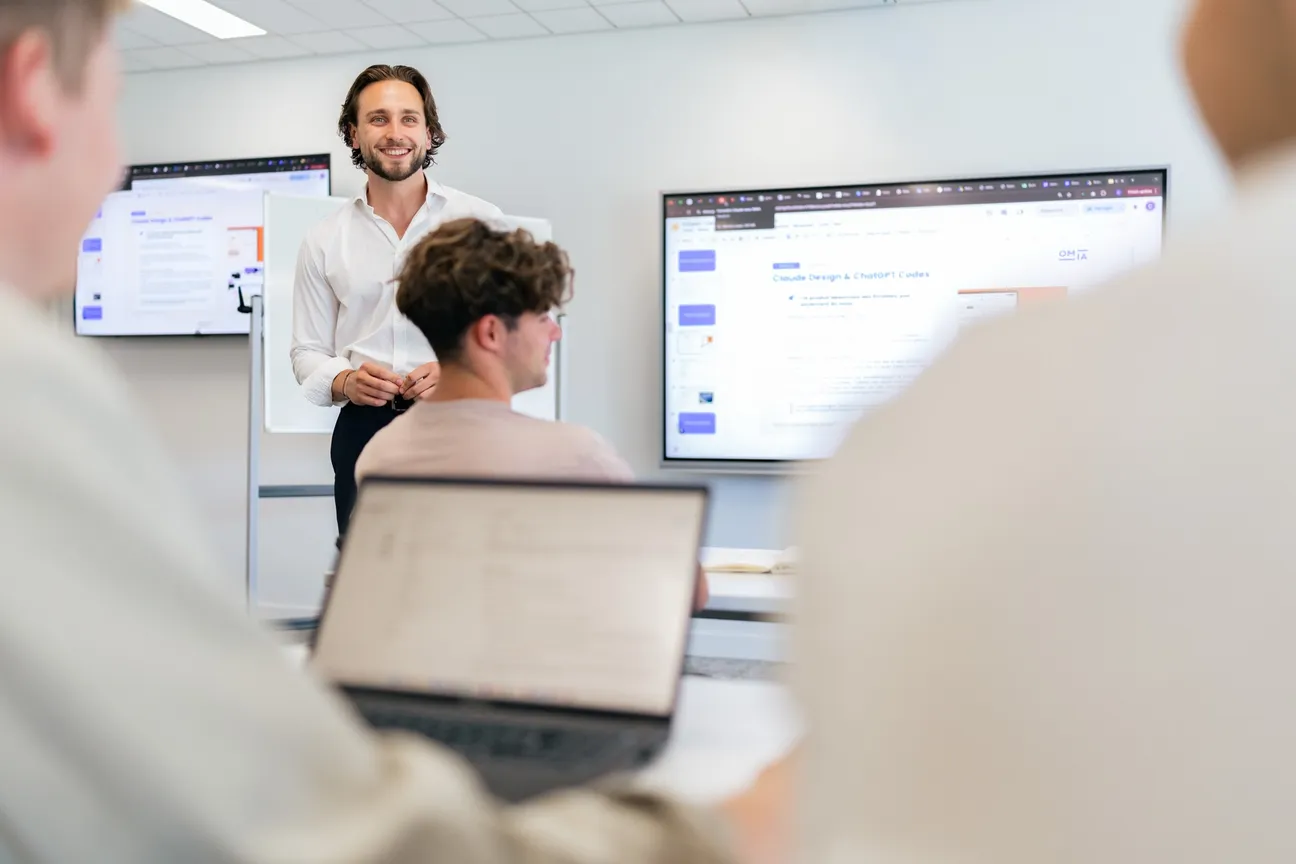 Depuis le fond de la salle, un formateur OMIA sourit à son groupe pendant une session de formation.